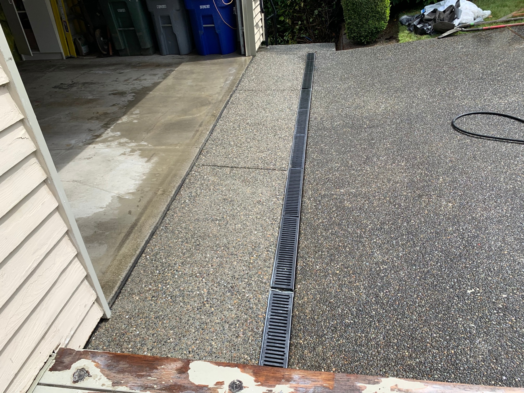 Exposed aggregate concrete with integrated trench drain at a residential driveway